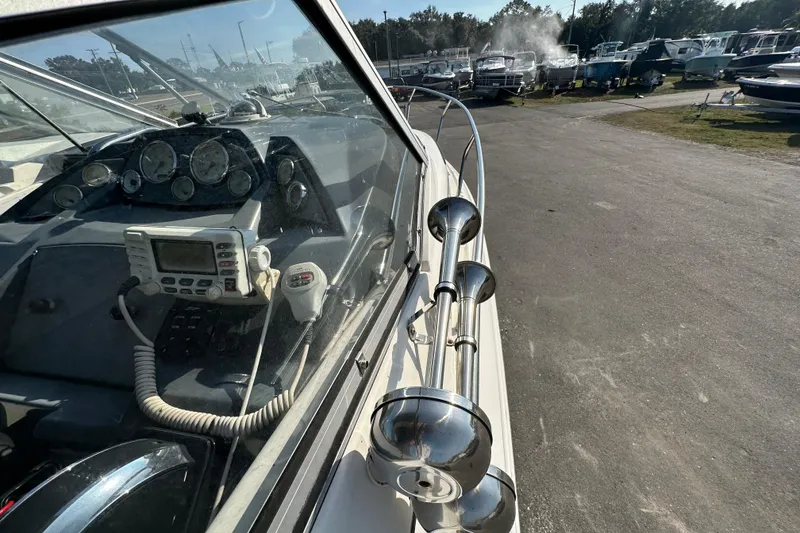 Slide: The Image of 2014 Larson Cabrio 265 boat dashboard with navigation equipment and horn, parked outdoors. - 24