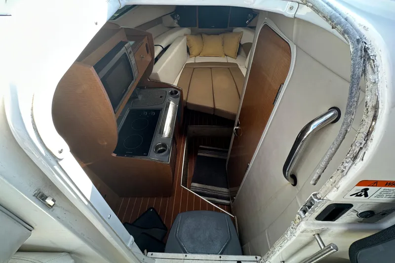 Slide: The Image of Interior of 2014 Larson Cabrio 265 boat with kitchenette and cozy seating area. - 26