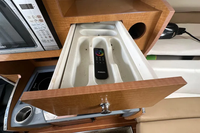 Slide: The Image of Drawer with remote control in 2014 Larson Cabrio 265 boat interior. - 29