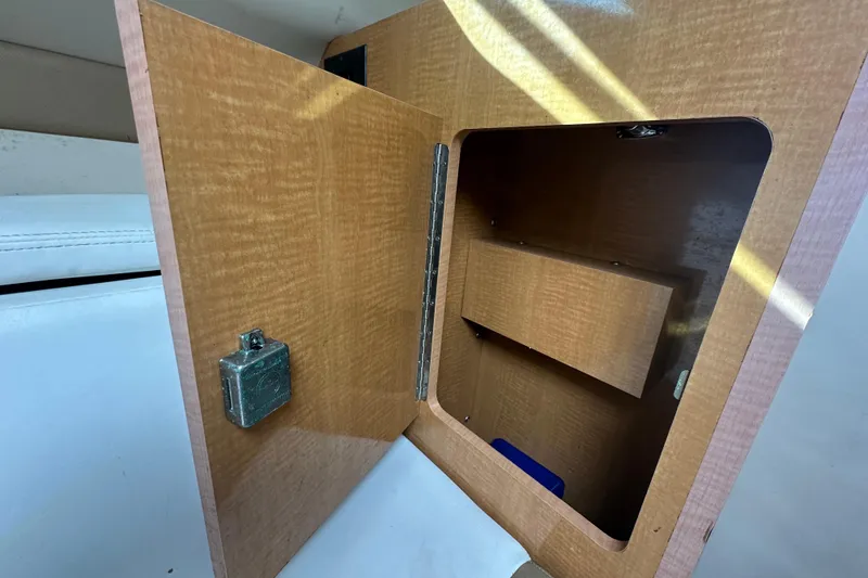 Slide: The Image of Open wooden cabinet inside 2014 Larson Cabrio 265 boat, showing interior storage space. - 35