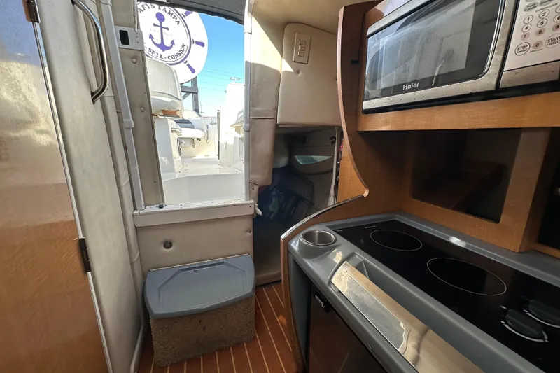 Slide: The Image of Interior of 2014 Larson Cabrio 265 boat with kitchen and microwave. - 40