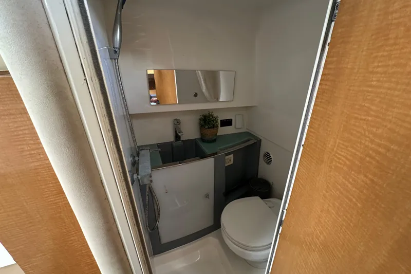 Slide: The Image of Compact bathroom in a 2014 Larson Cabrio 265 boat, featuring a toilet and sink. - 41