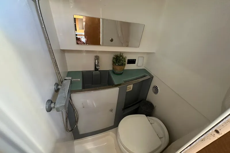 Slide: The Image of 2014 Larson Cabrio 265 boat bathroom with sink, mirror, and toilet. - 42
