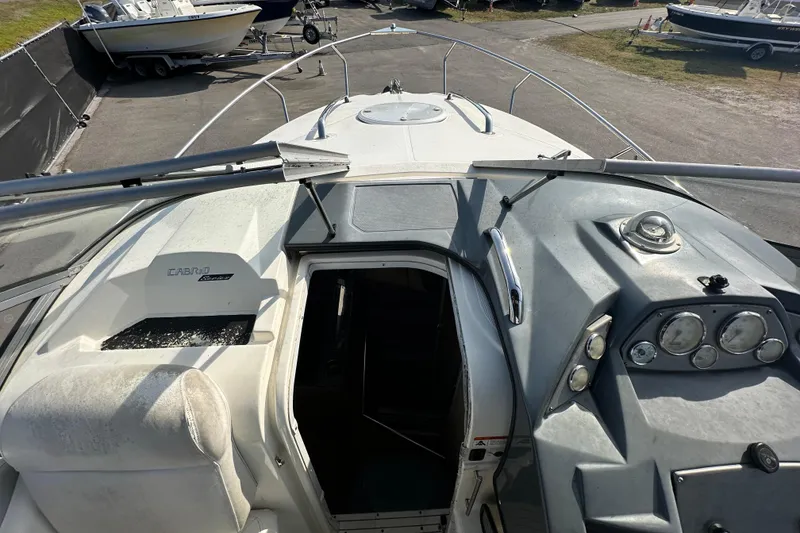 Slide: The Image of 2014 Larson Cabrio 265 boat interior view with dashboard and open cabin entrance. - 48