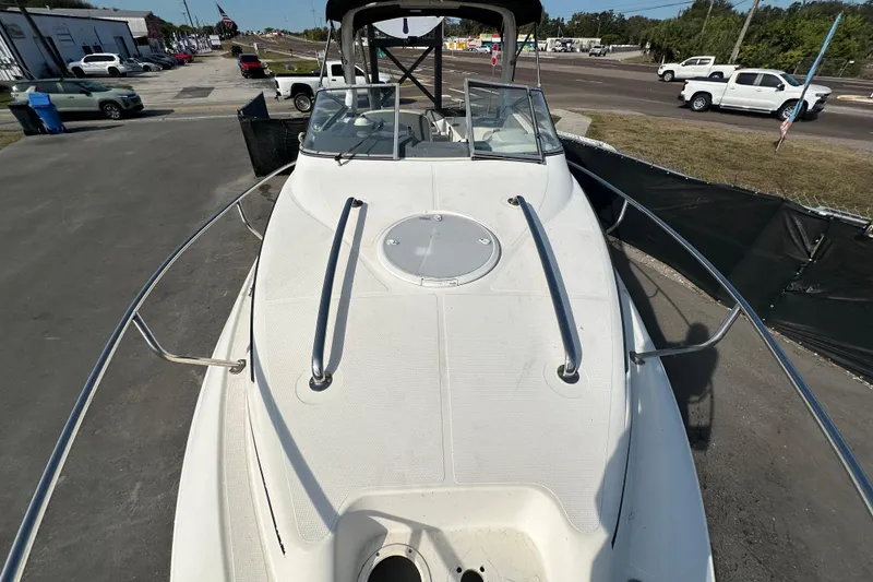 Slide: The Image of 2014 Larson Cabrio 265 boat on display in a parking lot. - 52