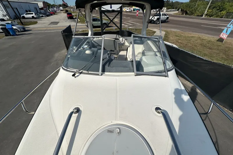 Slide: The Image of 2014 Larson Cabrio 265 boat, white exterior, docked in a parking area, sunny day. - 53