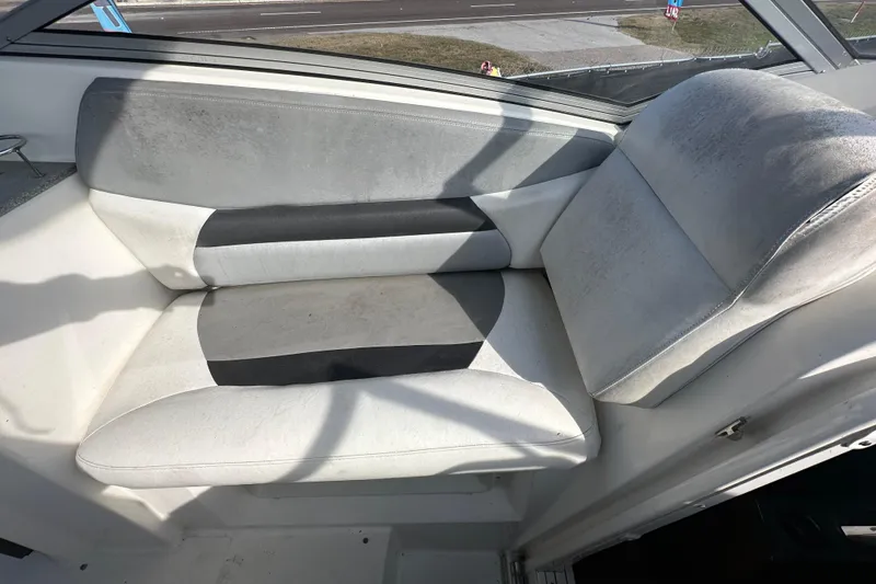 Slide: The Image of 2014 Larson Cabrio 265 boat interior with cushioned seating in white and gray. - 56