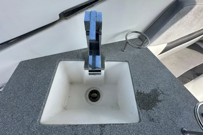 Slide: The Image of Sink area on a 2014 Larson Cabrio 265 boat with gray countertop. - 59