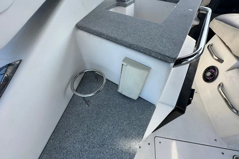 Slide: The Image of 2014 Larson Cabrio 265 boat interior with countertop, cup holder, and speaker. - 62