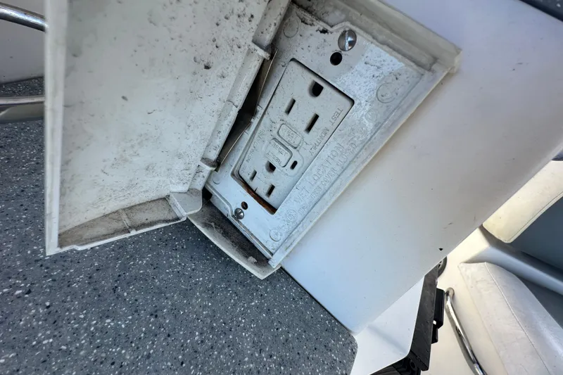Slide: The Image of Electrical outlet on 2014 Larson Cabrio 265 boat, featuring a protective cover. - 63
