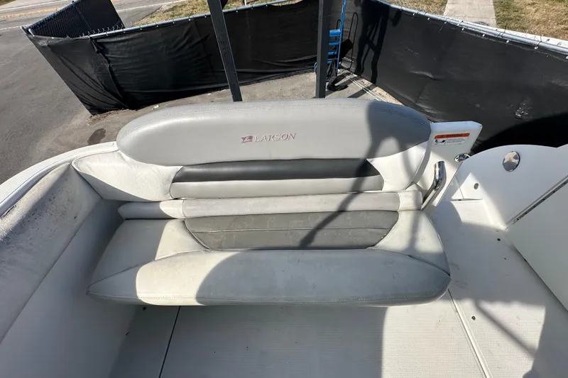 Slide: The Image of 2014 Larson Cabrio 265 boat seat, gray and white upholstery, outdoor setting. - 66