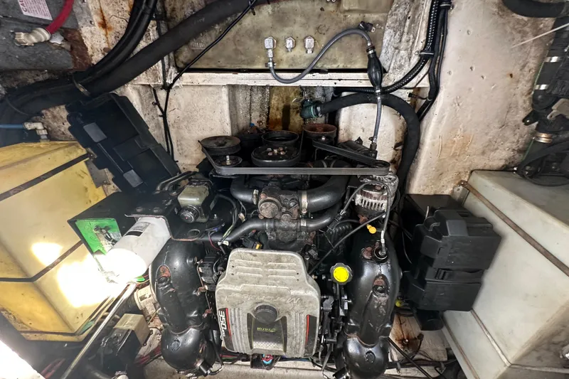 Slide: The Image of Engine compartment of a 2014 Larson Cabrio 265 boat, showcasing mechanical components and wiring. - 70