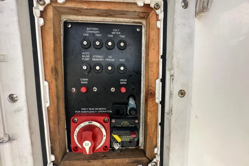 Slide: The Image of Control panel of a 2014 Larson Cabrio 265 boat, featuring switches and circuit breakers. - 74