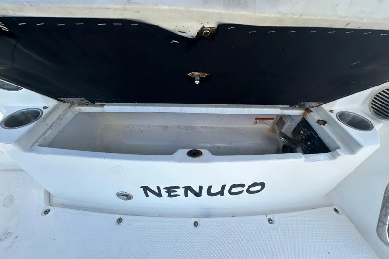 Slide: The Image of 2014 Larson Cabrio 265 boat storage compartment labeled "NENUCO" with cup holders. - 76