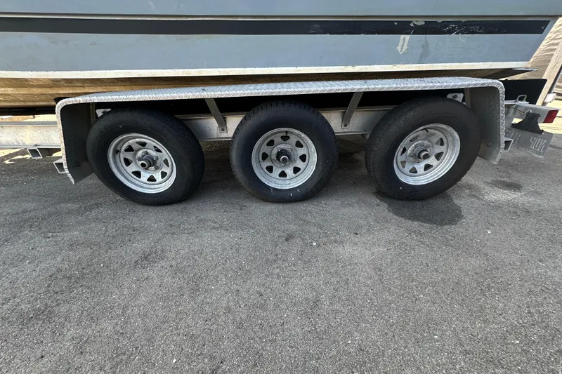 Slide: The Image of Triple-axle trailer for 2014 Larson Cabrio 265 boat on asphalt surface. - 78