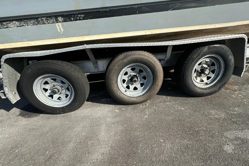 Slide: The Image of Triple-axle trailer for 2014 Larson Cabrio 265 boat on asphalt surface. - 79
