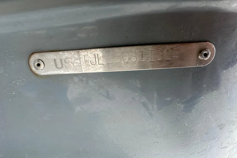 Slide: The Image of 2014 Larson Cabrio 265 hull identification number plate on a gray surface. - 80