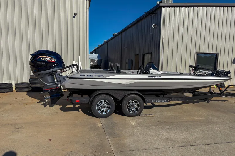 The Image of 2026 Skeeter ZXR20 SE boat with Yamaha engine, parked outside a metal building. - 0