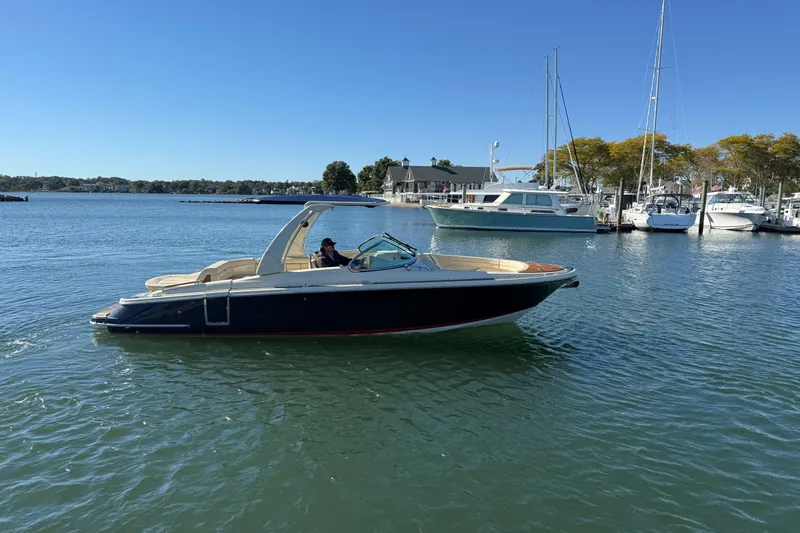 The Image of 2019 Chris-Craft Launch 28 GT boat cruising in a marina under clear blue skies. - 0