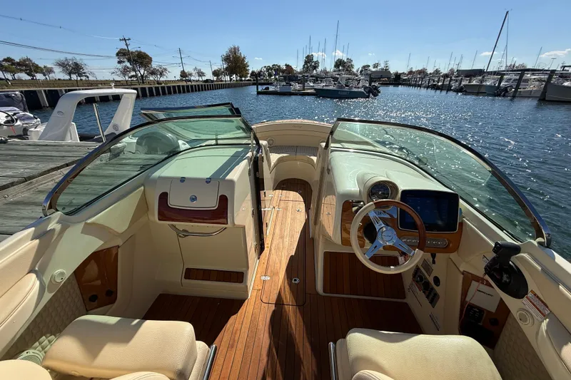 Slide: The Image of 2019 Chris-Craft Launch 28 GT boat interior with wooden deck and steering wheel. - 14
