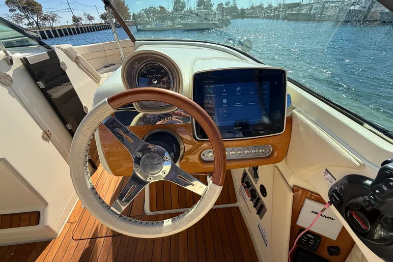 Slide: The Image of 2019 Chris-Craft Launch 28 GT dashboard with wooden steering wheel and digital display. - 16