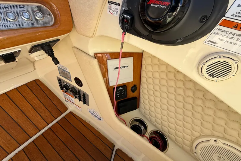 Slide: The Image of 2019 Chris-Craft Launch 28 GT boat interior with Mercury controls and teak flooring. - 18