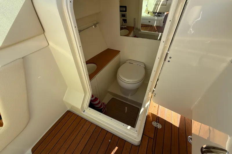 Slide: The Image of 2019 Chris-Craft Launch 28 GT boat interior with compact bathroom and wooden flooring. - 20