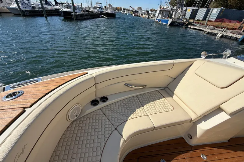 Slide: The Image of 2019 Chris-Craft Launch 28 GT boat interior with beige seating and wooden deck. - 24