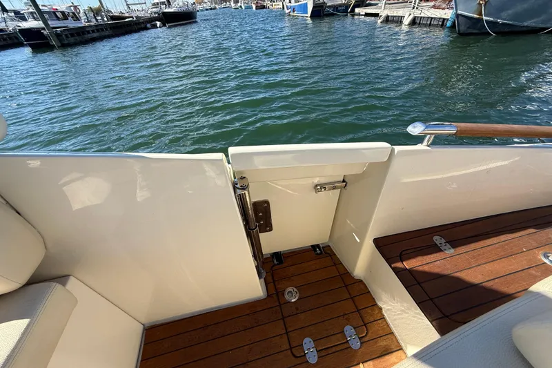 Slide: The Image of 2019 Chris-Craft Launch 28 GT boat interior with wooden deck and water view. - 6