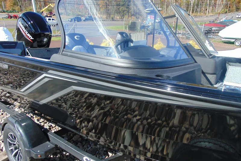 Slide: The Image of 2026 Crestliner 1750 Hawk boat with sleek black exterior and Mercury engine. - 14