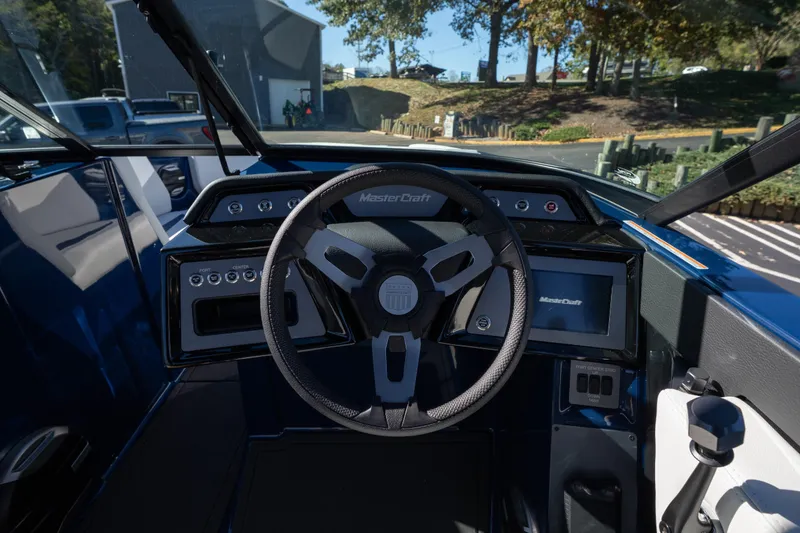 Slide: The Image of 2026 MasterCraft NXT23 boat dashboard with steering wheel and control panel. - 10