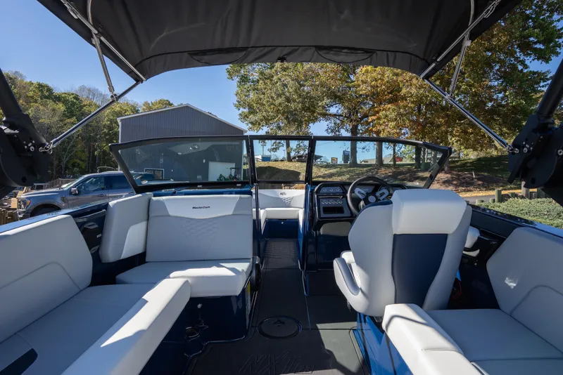 Slide: The Image of Interior view of 2026 MasterCraft NXT23 boat with seating and steering wheel. - 2