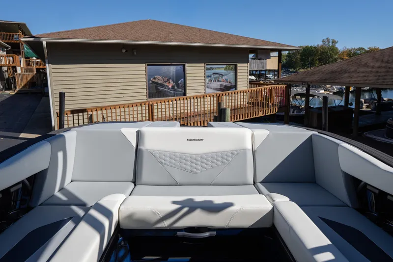 Slide: The Image of 2026 MasterCraft NXT23 boat interior with gray seating at a marina. - 3