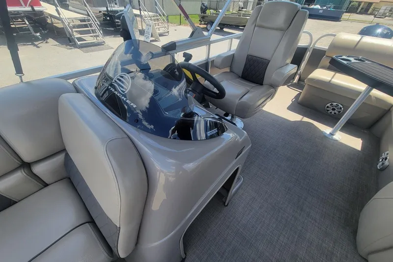 Slide: The Image of 2023 Sun Tracker Party Barge 20 DLX interior with helm, seating, and table. - 11