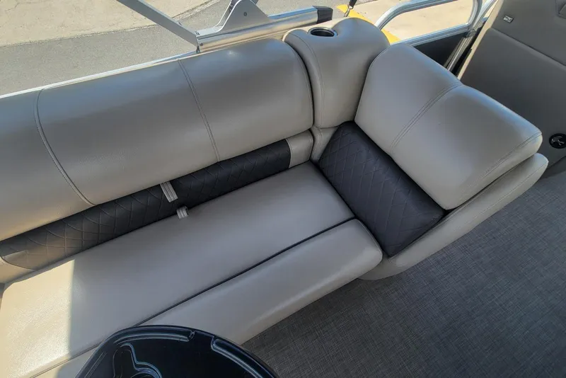 Slide: The Image of 2023 Sun Tracker Party Barge 20 DLX interior seating with gray upholstery and cup holder. - 13