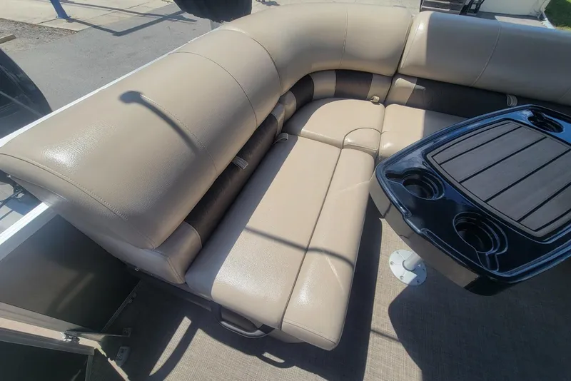 Slide: The Image of 2023 Sun Tracker Party Barge 20 DLX interior with beige seating and black table. - 14