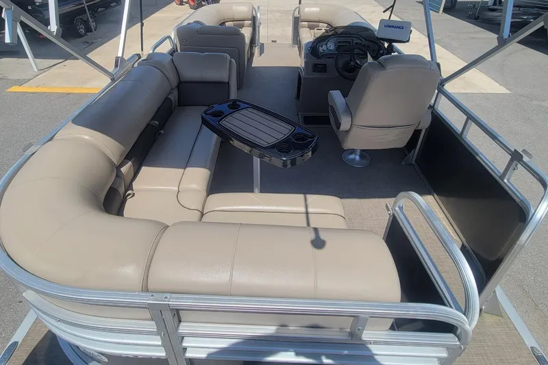 Slide: The Image of 2023 Sun Tracker Party Barge 20 DLX interior with beige seating and steering console. - 17