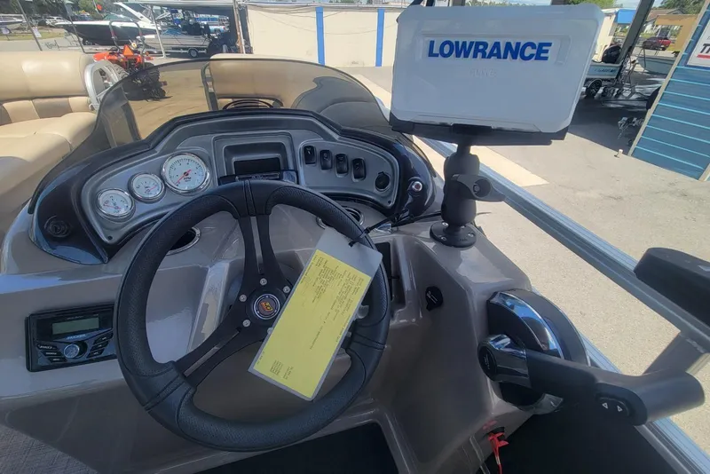 Slide: The Image of 2023 Sun Tracker Party Barge 20 DLX dashboard with steering wheel and Lowrance GPS system. - 19
