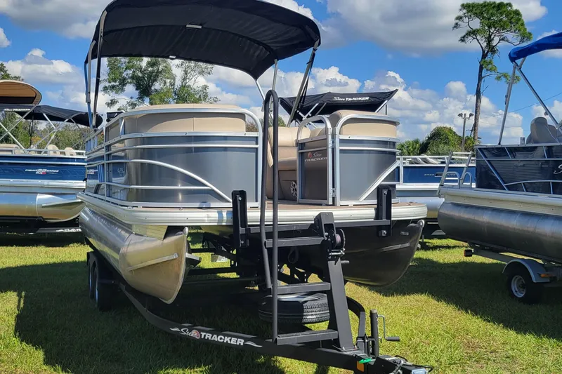 Slide: The Image of 2023 Sun Tracker Party Barge 20 DLX pontoon boat on trailer, displayed outdoors. - 4