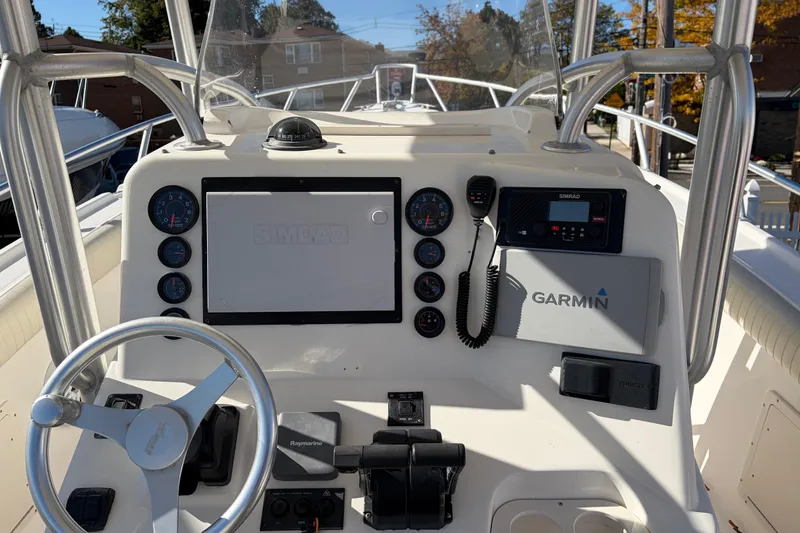 Slide: The Image of 2006 Mako 284 Center Console boat dashboard with Garmin and Simrad electronics. - 7