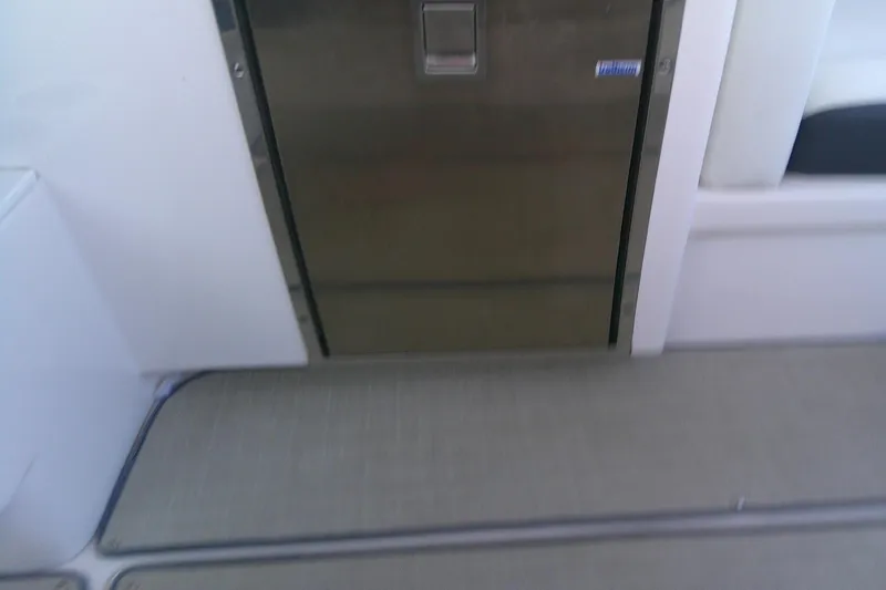 Slide: The Image of 2022 Regal 29 OBX boat interior with stainless steel door and cushioned seating. - 17