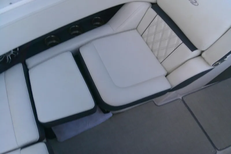 Slide: The Image of 2022 Regal 29 OBX boat interior with white cushioned seating and cup holders. - 22