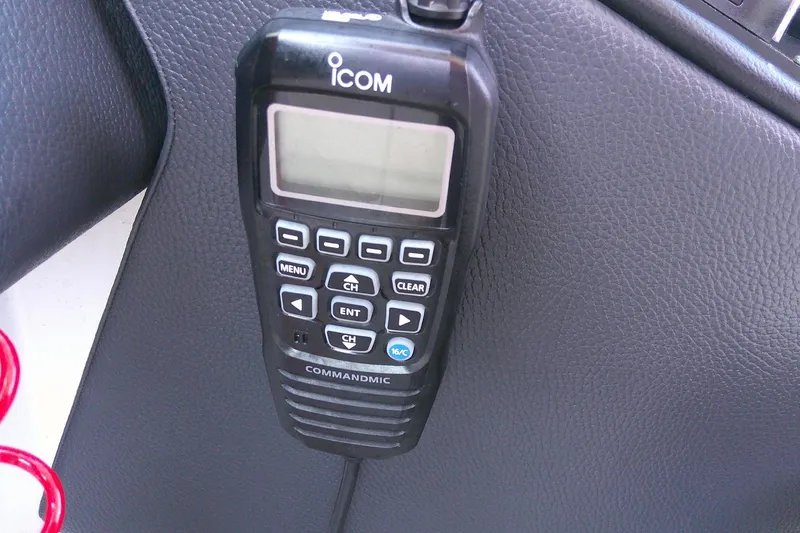 Slide: The Image of ICOM CommandMic on 2022 Regal 29 OBX boat dashboard, black leather background. - 25