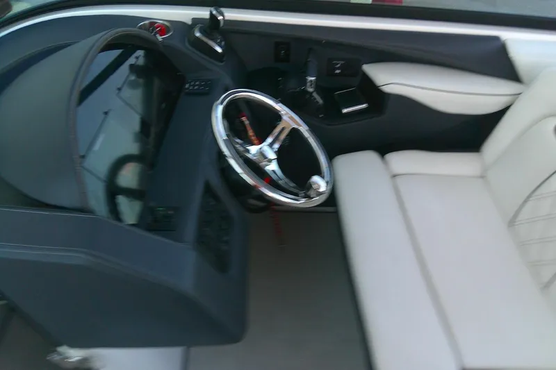 Slide: The Image of 2022 Regal 29 OBX boat interior with steering wheel and seating area. - 29