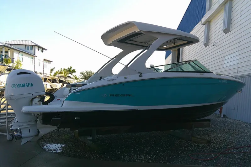 Slide: The Image of 2022 Regal 29 OBX boat with Yamaha outboard engine, docked near a building. - 3
