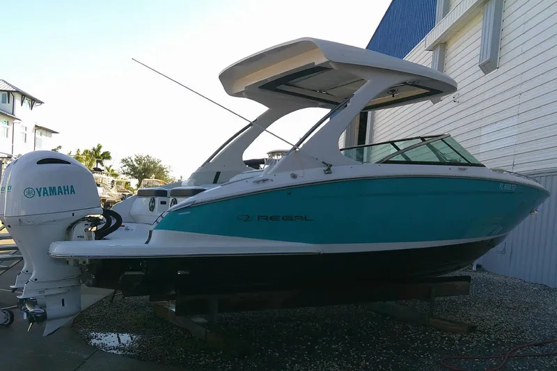 Slide: The Image of 2022 Regal 29 OBX boat with Yamaha outboard engine, docked near a building. - 7