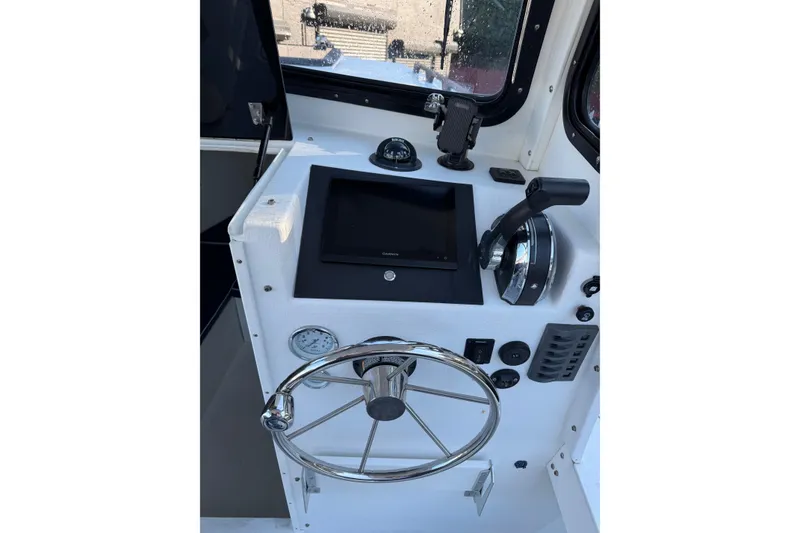 Slide: The Image of 2016 Eastern Seaway boat helm with steering wheel, throttle, and navigation controls. - 5