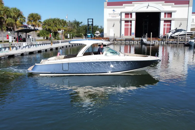 The Image of 2022 Chris-Craft Launch 35 GT I/O boat cruising near a marina. - 0