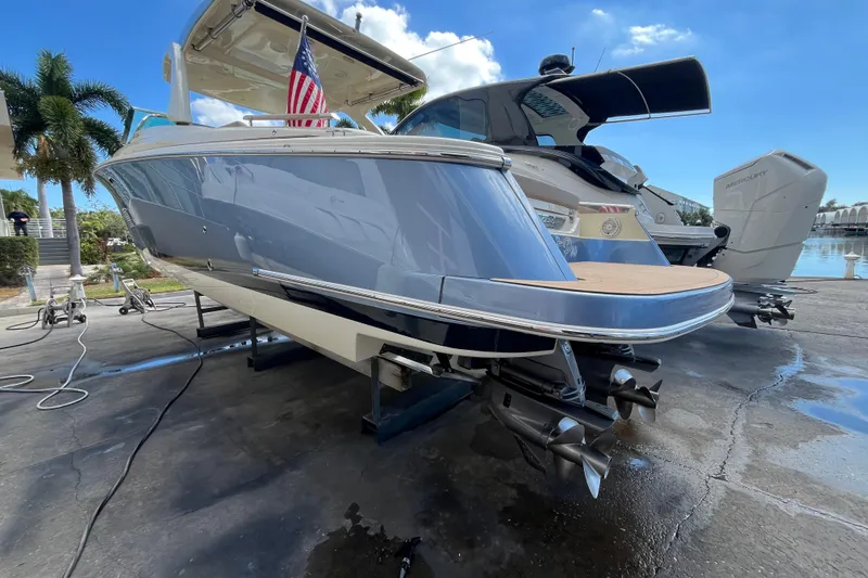 Slide: The Image of 2022 Chris-Craft Launch 35 GT I/O boat on dock, showcasing sleek design and dual propellers. - 10