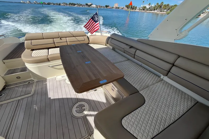 Slide: The Image of 2022 Chris-Craft Launch 35 GT I/O boat interior with seating and table, cruising on water. - 13